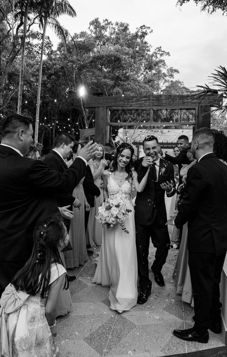 Recém casados saindo da cerimonia de casamento confraternizando