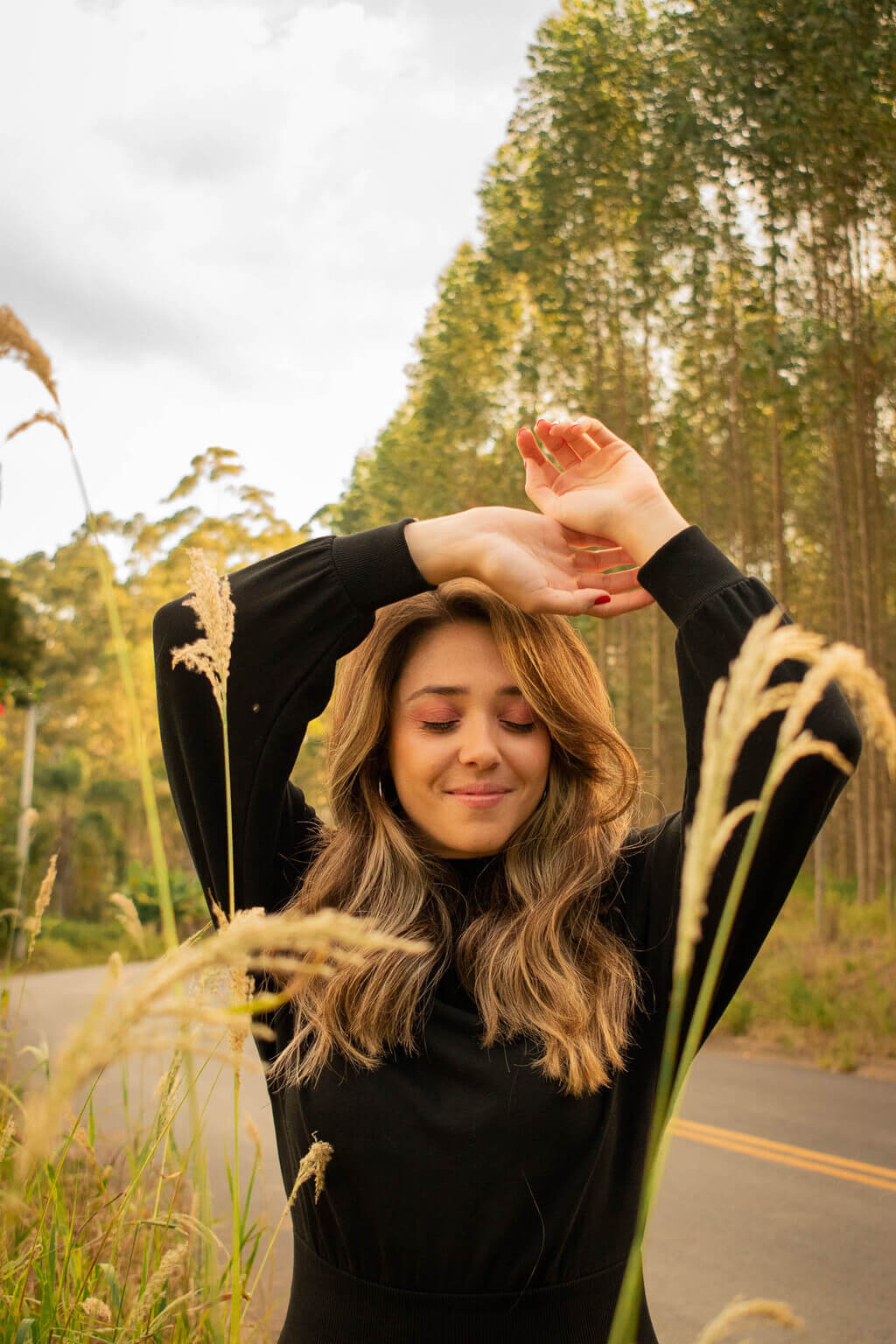 Mulher posa alegremente em mata para foto em ensaio fotográfico feminino