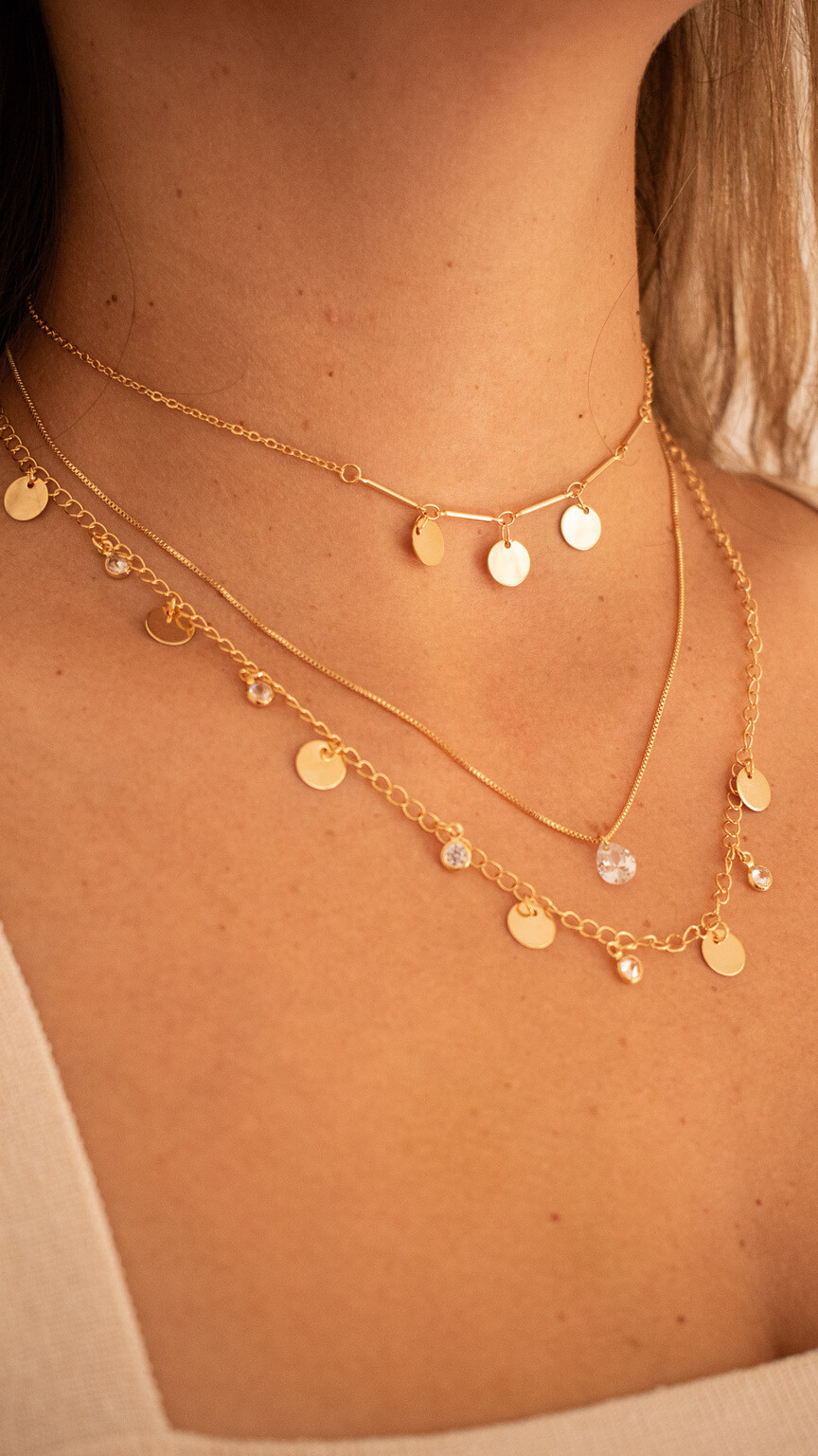 Foto de um produto colar dourado em modelo feminino